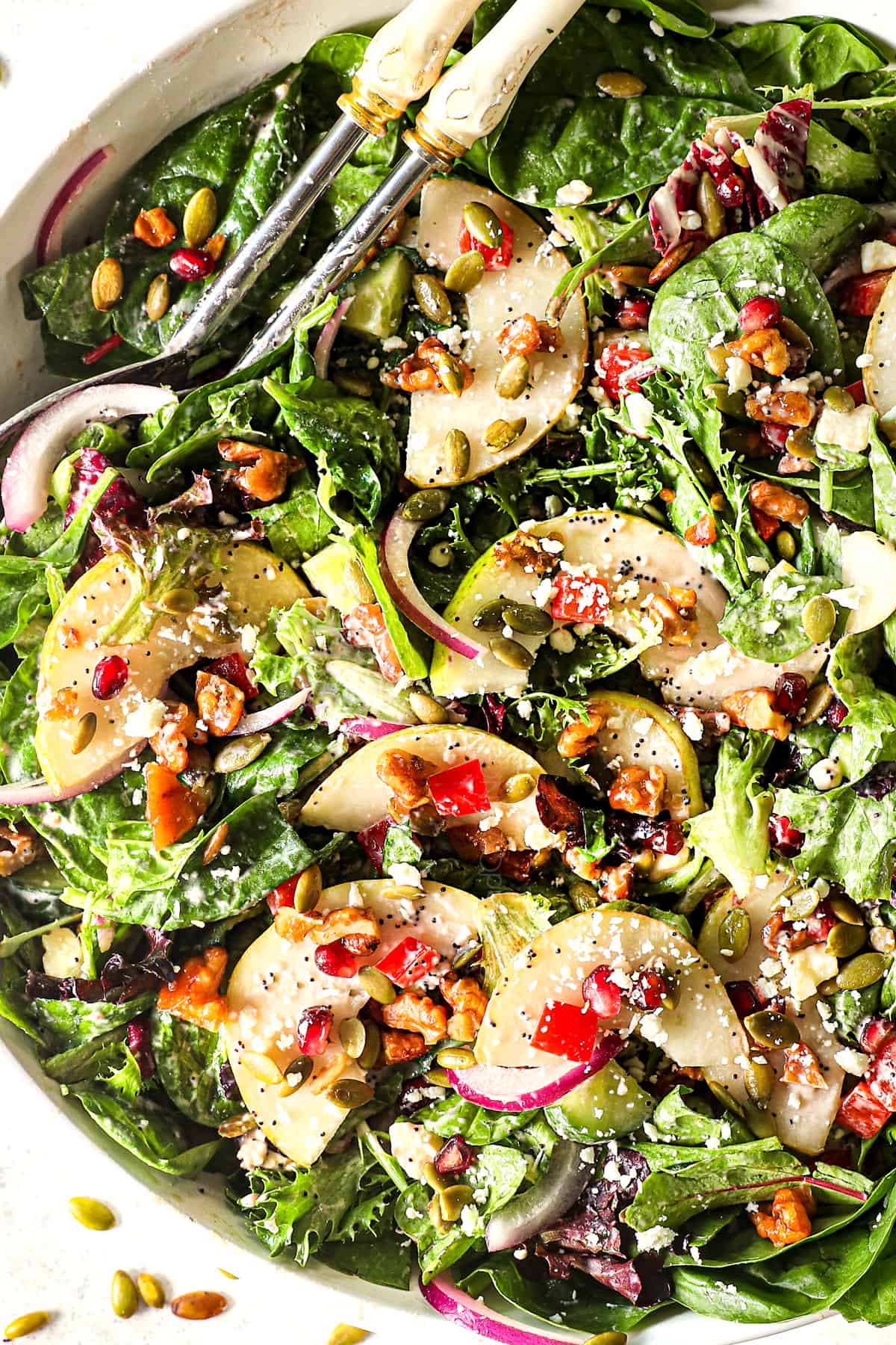 showing how to make pear salad recipe by tossing the salad ingredients together in a bowl