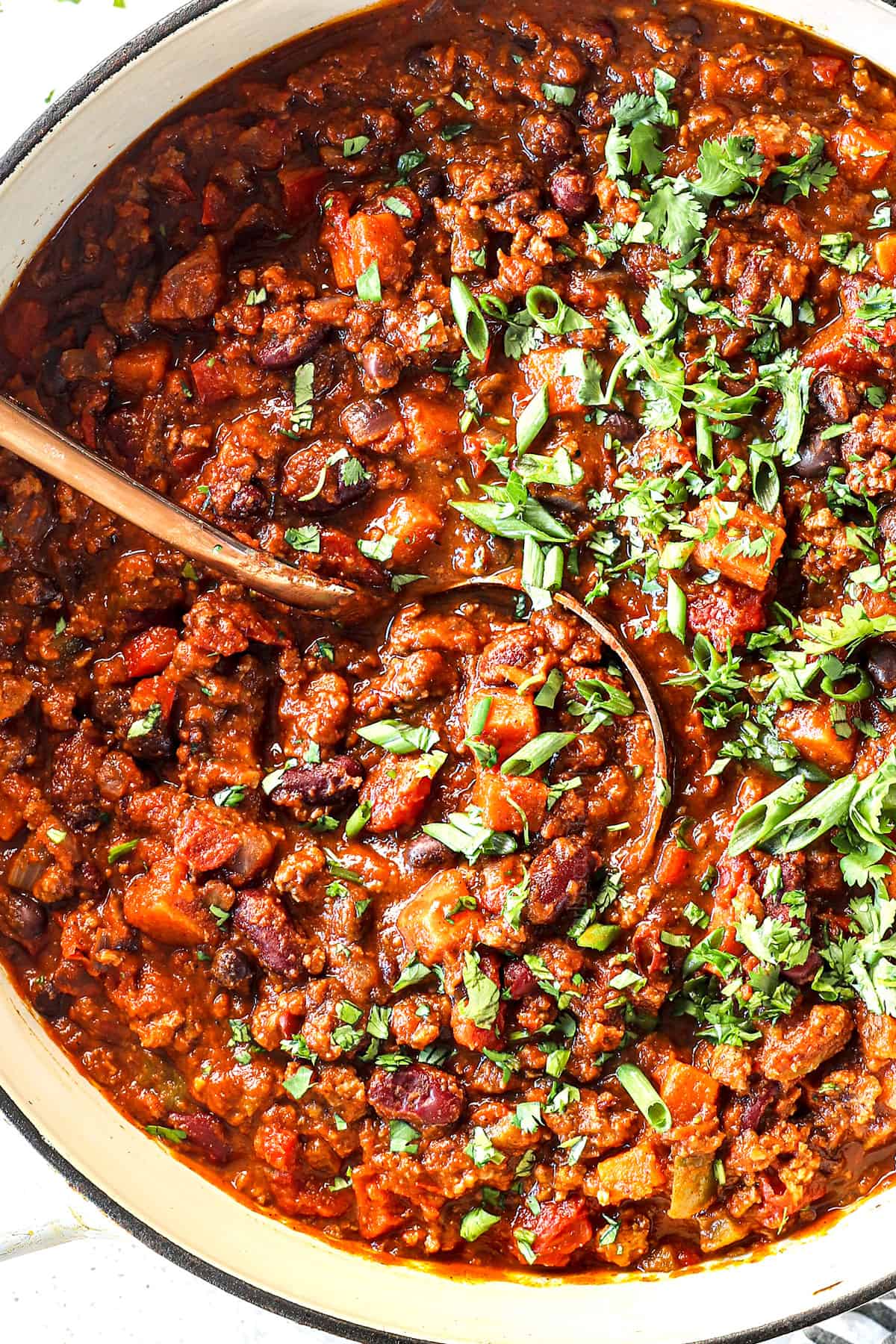 showing how to make pumpkin chili by adding cilantro to the chili