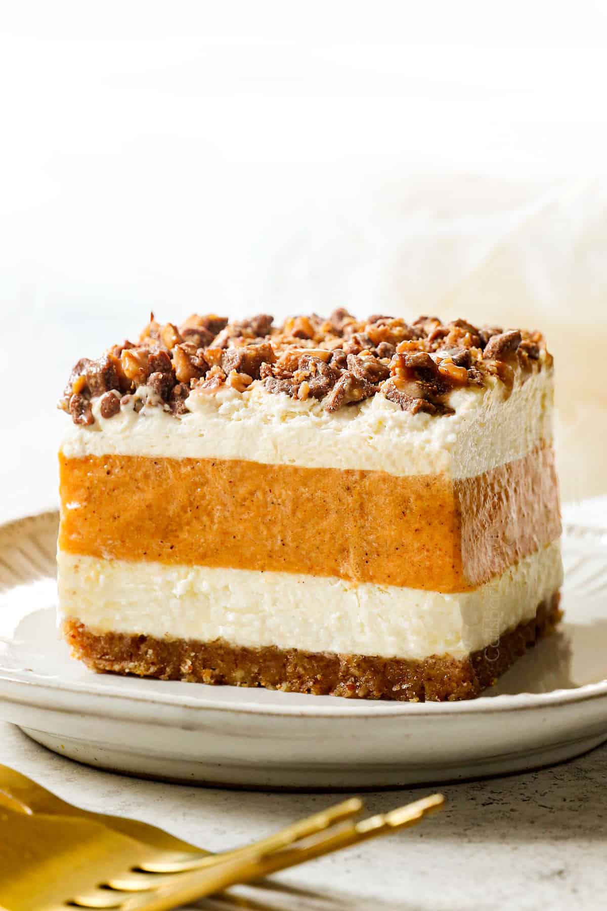 a slice of pumpkin delight (pumpkin lush) on a plate with toffee bits topping