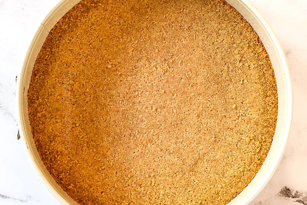 showing how to make Caramel Apple Cheesecake by pushing Graham crackers into springform pan