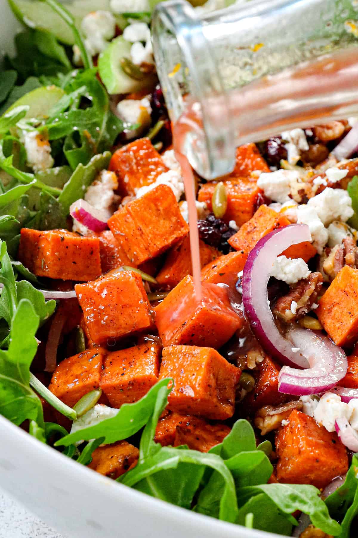 showing how to make sweet potato salad recipe by adding pomegranate orange vinaigrette