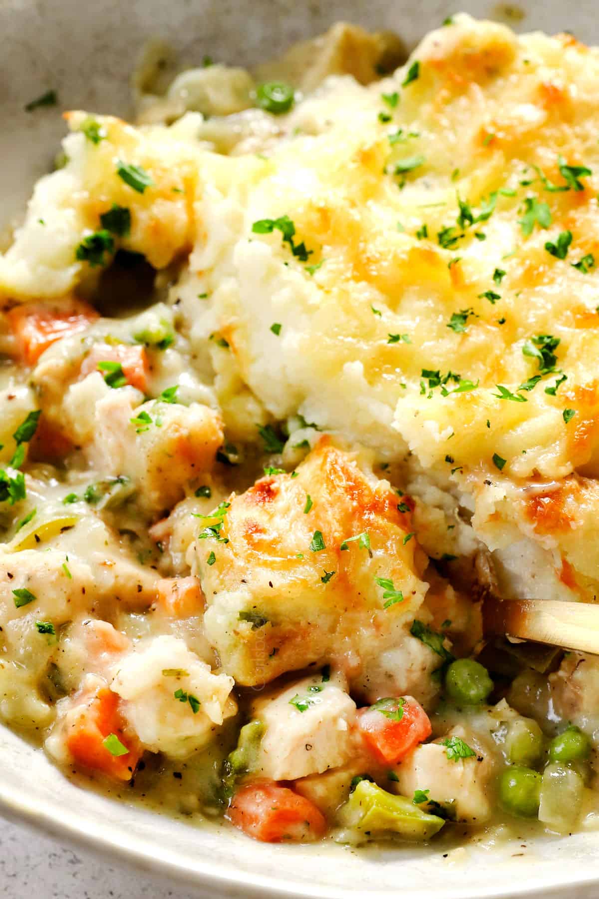 up close of serving turkey shepherds pie showing the creamy filling with leftover turkey with mashed potatoes