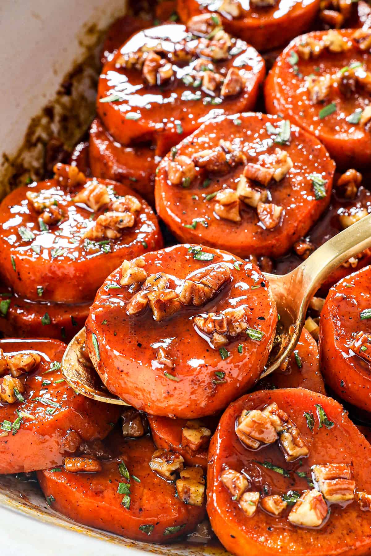 up close of serving candied yams recipe (candied sweet potatoes) garnished with pecans