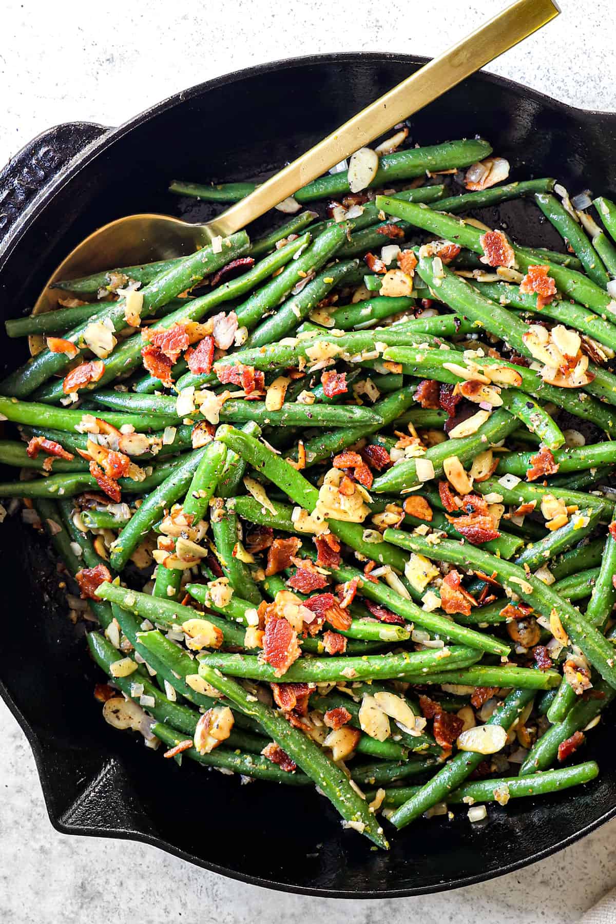 top view of making Green Beans Almondine by sautéing greens with butter, almonds, garlic and shallots