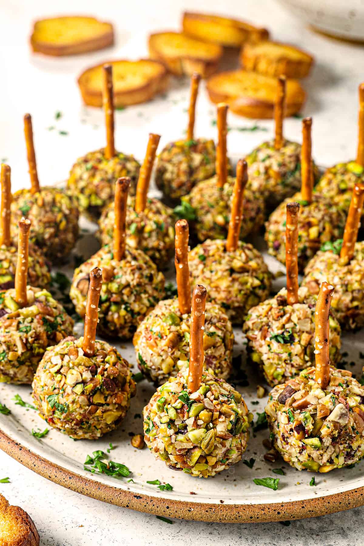 a platter of mini cheese balls with pretzel sticks