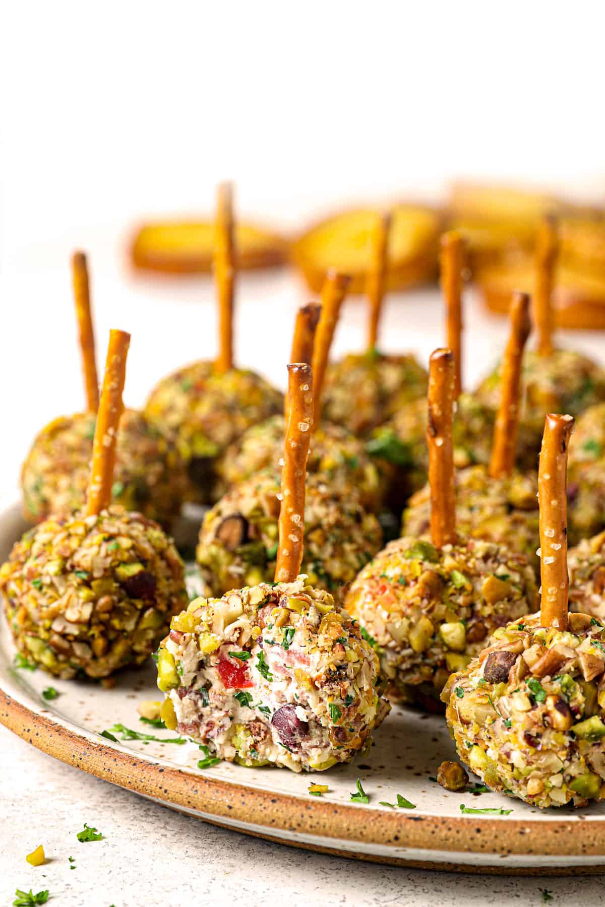 mini cheese balls recipe on a platter with a bite taken out showing the cream cheese mixture