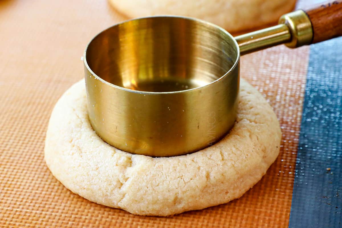 showing how to make pecan pie cookies by making a larger thumbprint in the baked cookies