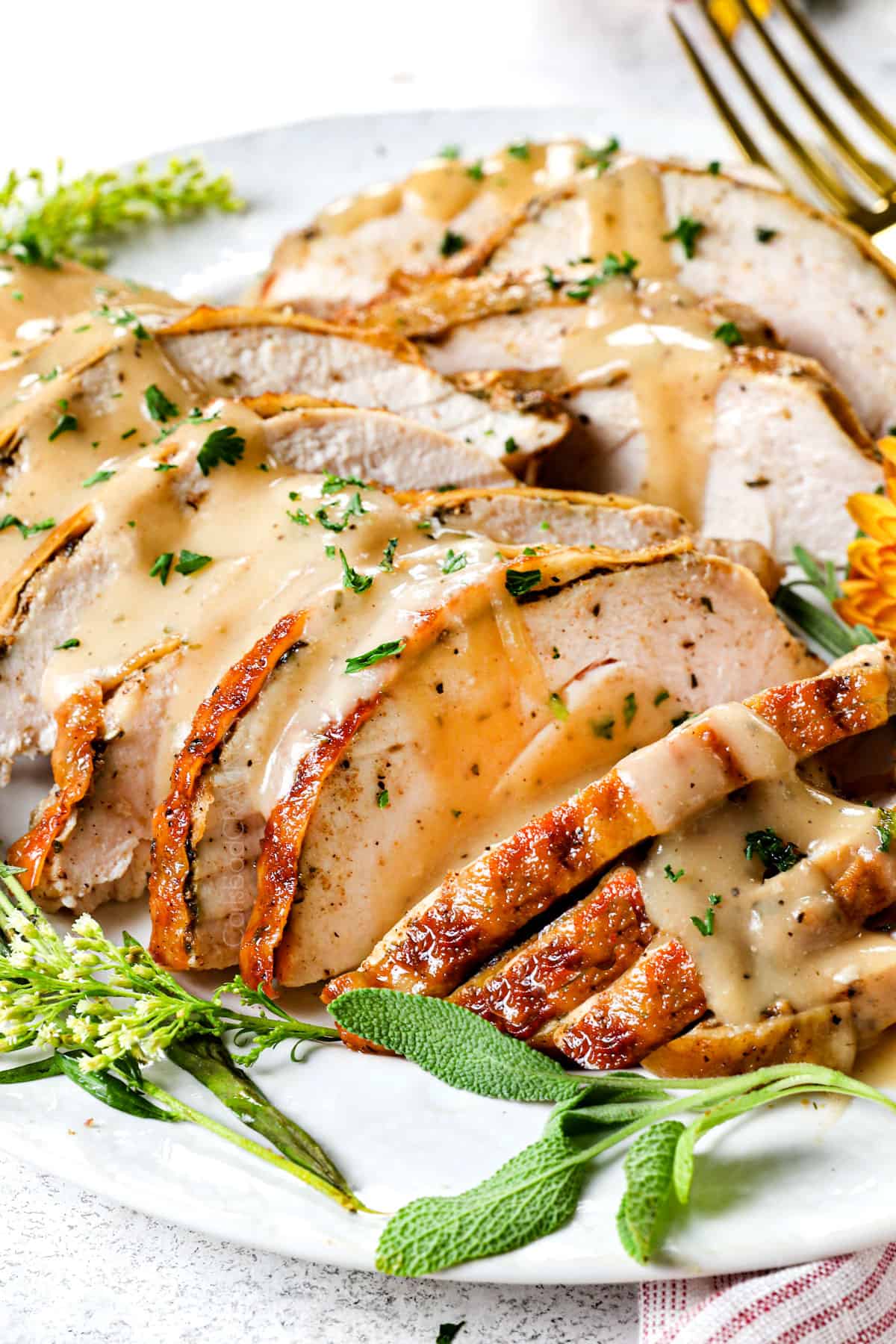 showing how to serve oven roasted turkey breast on a plate with gravy