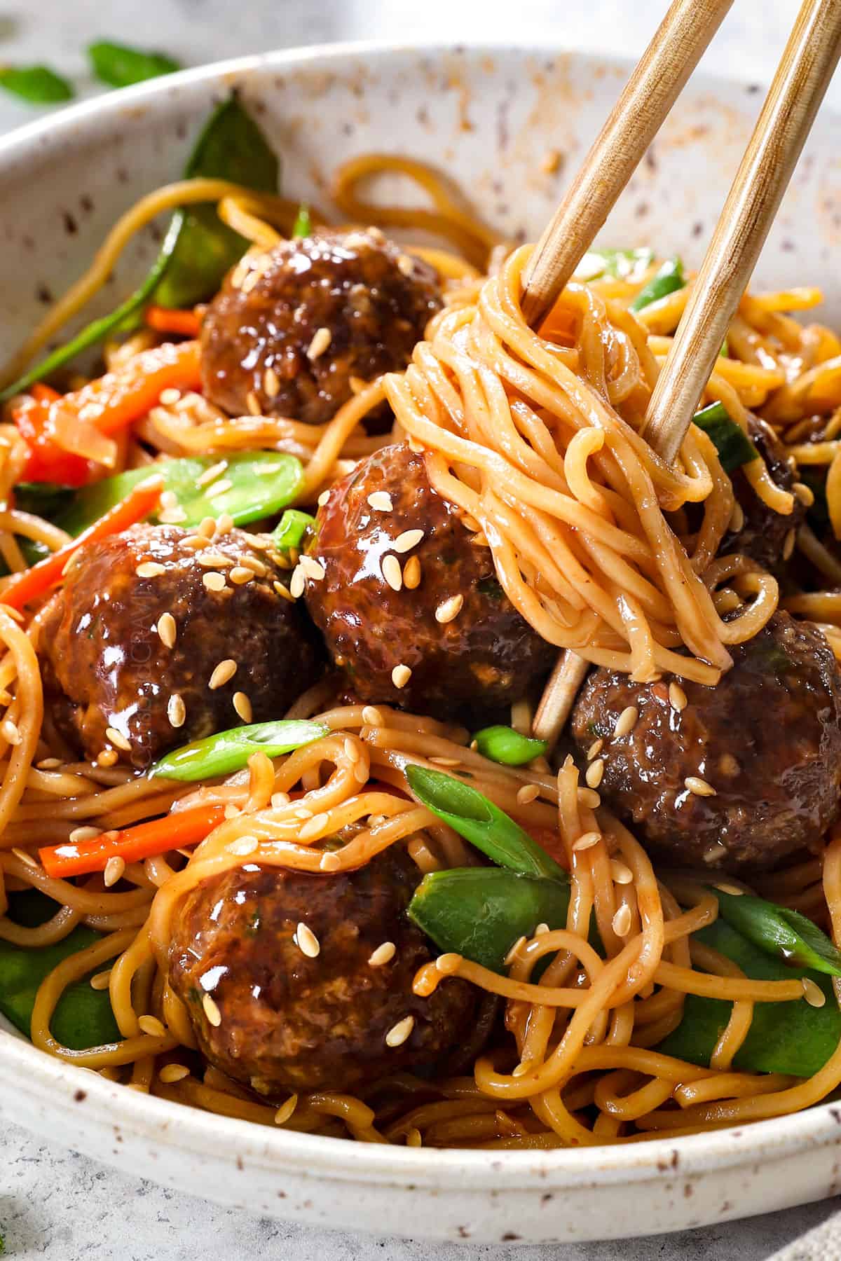 eating Asian meatballs by picking up meatballs with chopsticks