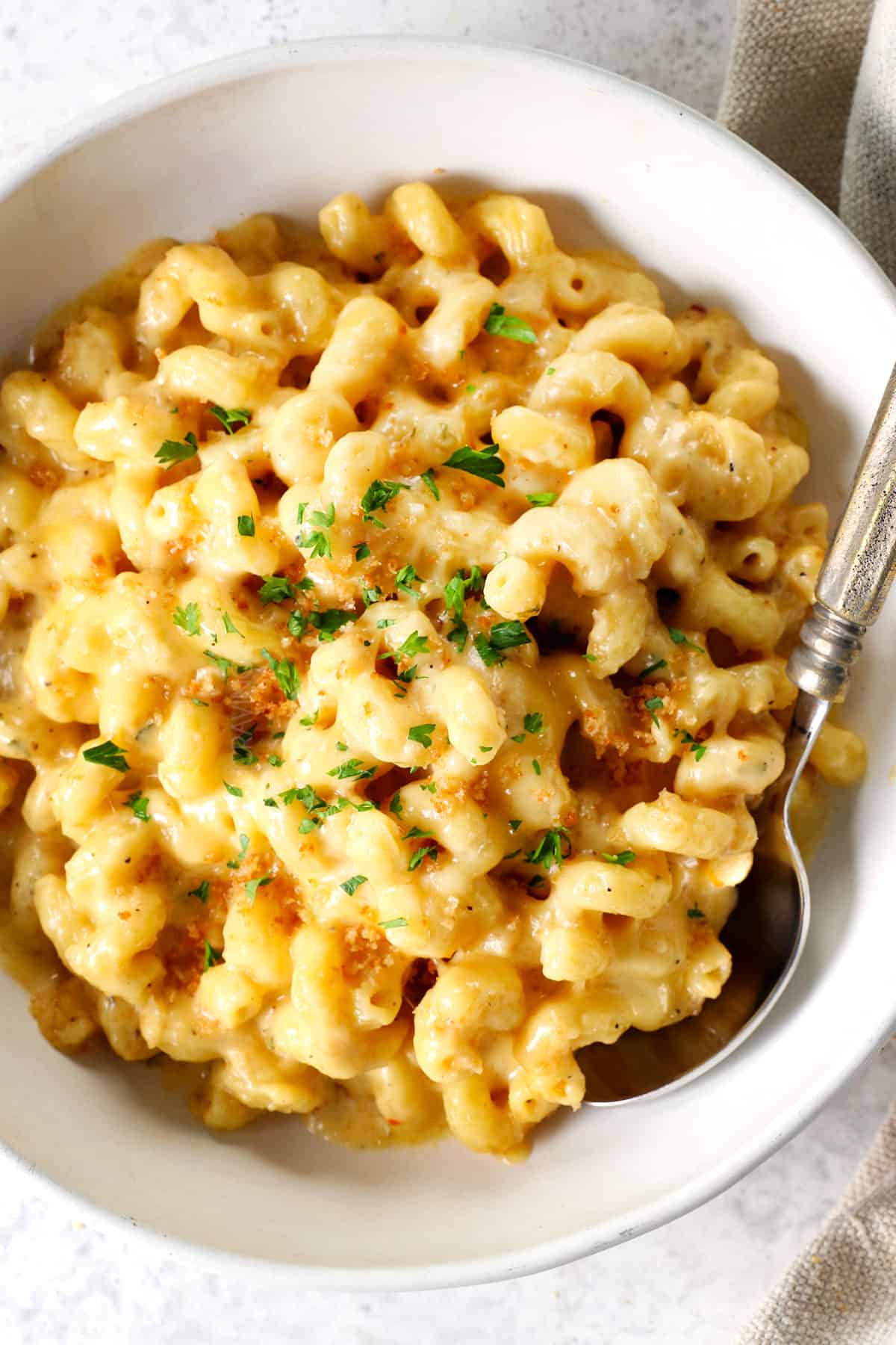 showing how to serve best baked macaroni and cheese in a bowl garnished with Parmesan and parsley