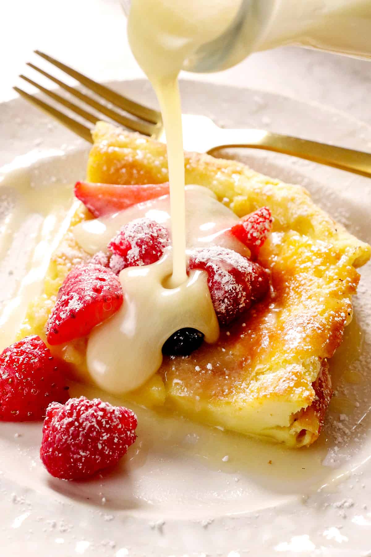 showing how to serve German pancakes by pouring syrup over a slice