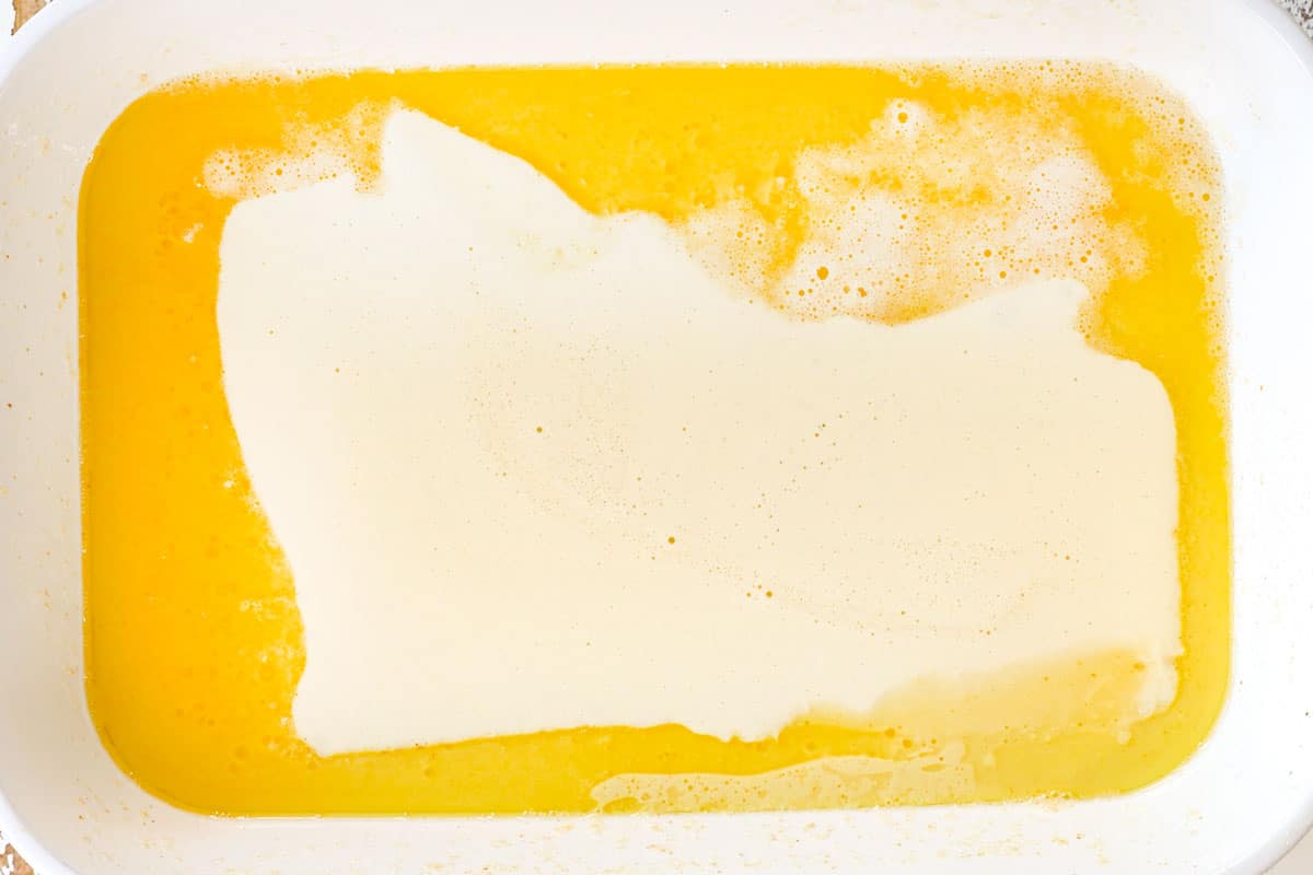 showing how to make German Pancake recipe adding butter to melted butter in pan