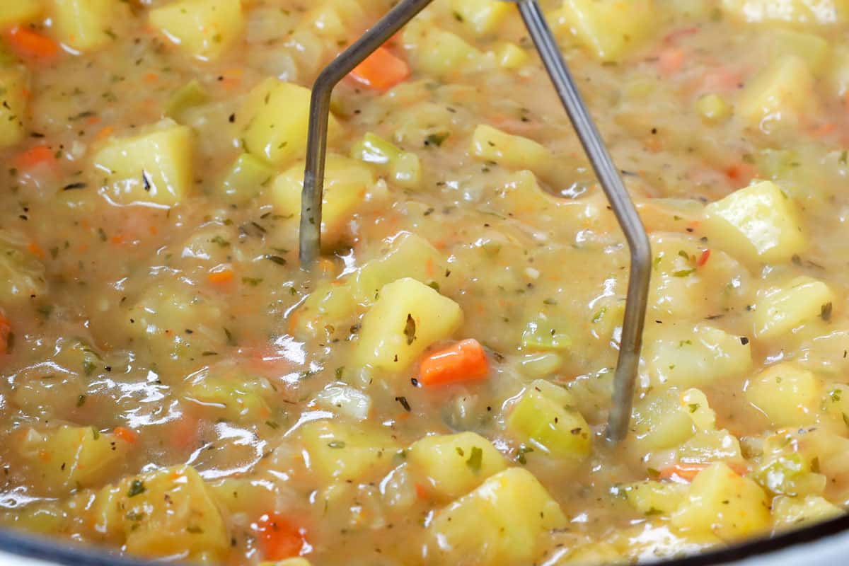 making ham and potato soup by mashing potatoes in the soup to make it creamy