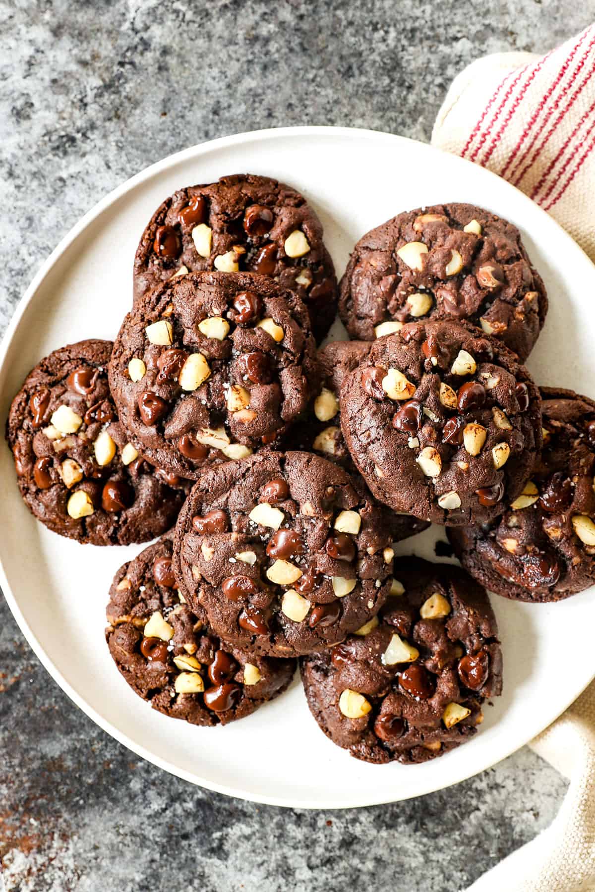 top view of a plate of chocolate macadamia nut cookies with chocolate chips