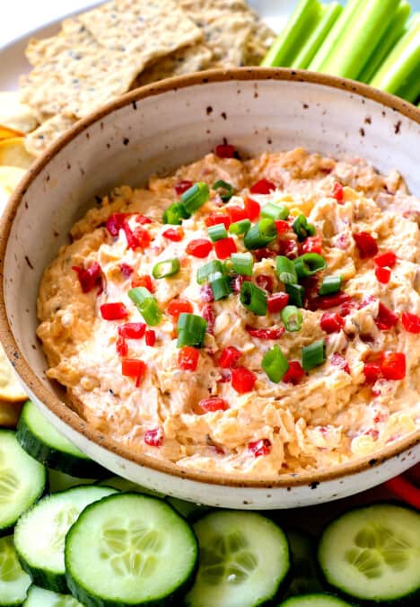 showing how to serve pimento cheese recipe adding to a platter with cucumbers, celery, bell peppers, cauliflower and crackers