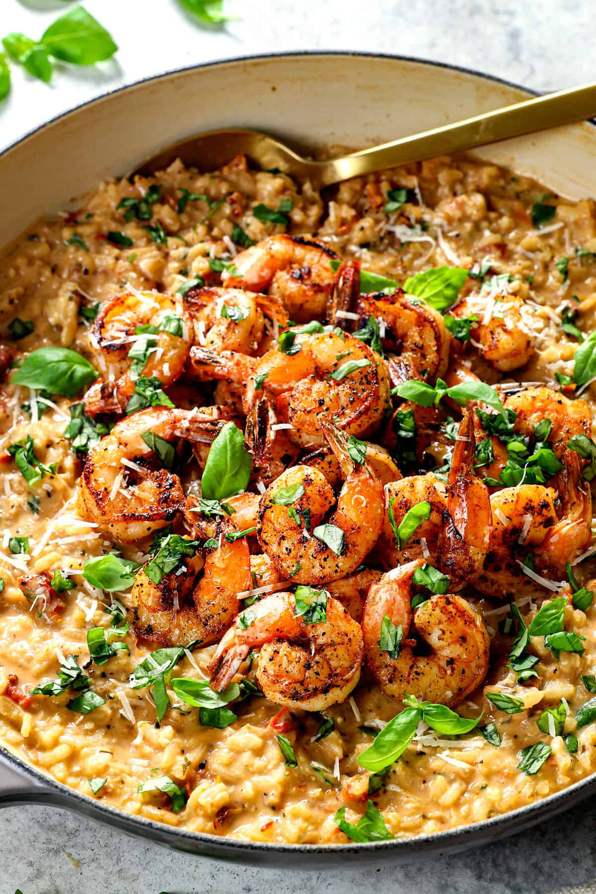 showing how to make creamy Italian shrimp risotto recipe by garnishing with basil