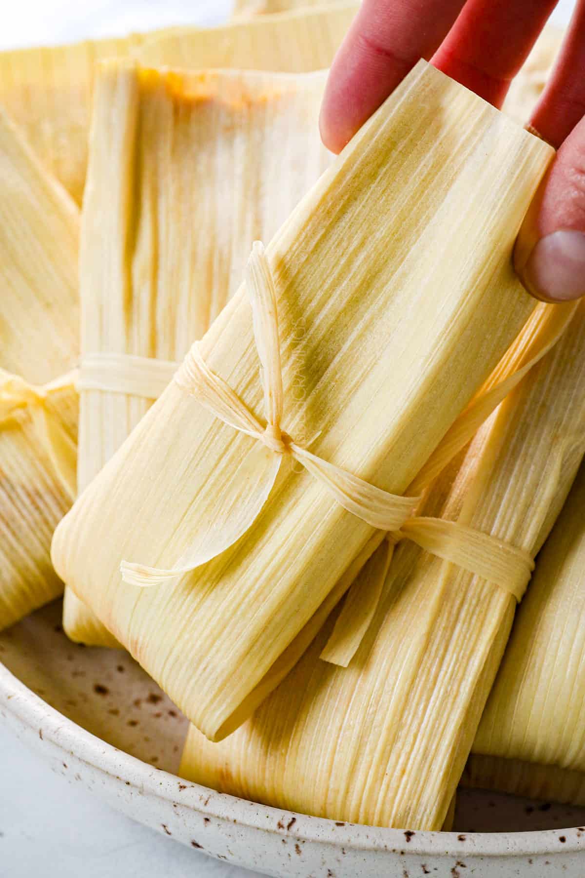 showing how to make Tamales by tying tamales and stacking