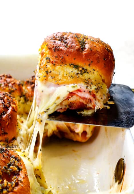 up close of ham and cheese sliders made with Hawaiian rolls baked in a 9x13 casserole dish