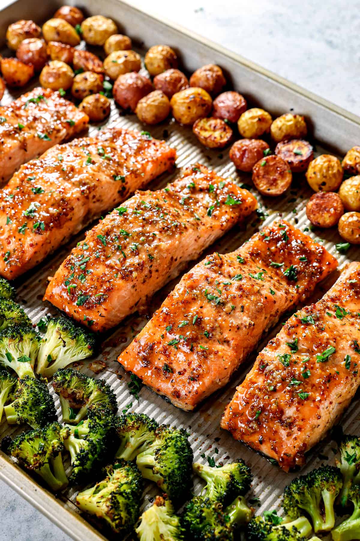 showing how to make honey mustard salmon by lining the salmon fillets on a baking sheet