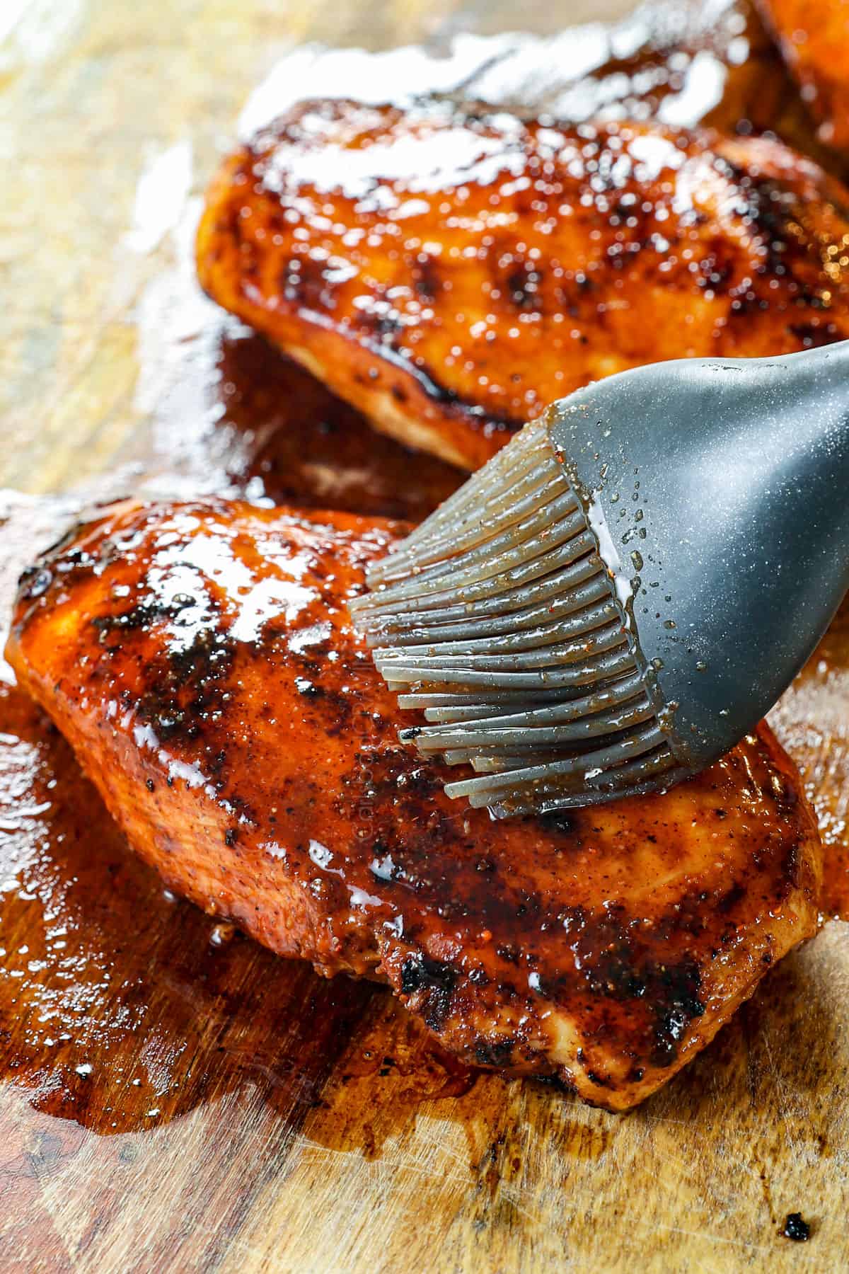showing how to make buffalo chicken wraps by brushing the buffalo chicken with a buffalo glaze before slicing