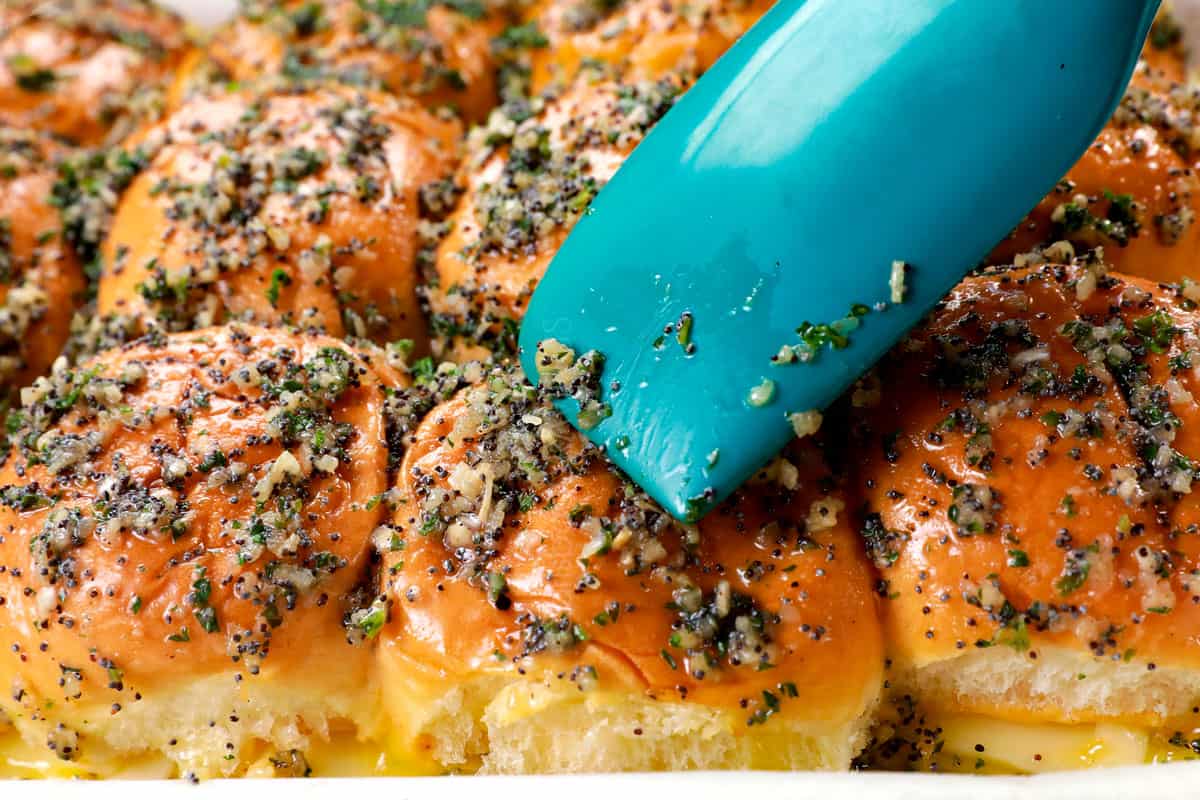 showing how to make ham and cheese slider recipe on Hawaiian rolls by spreading the tops with poppy seed butter