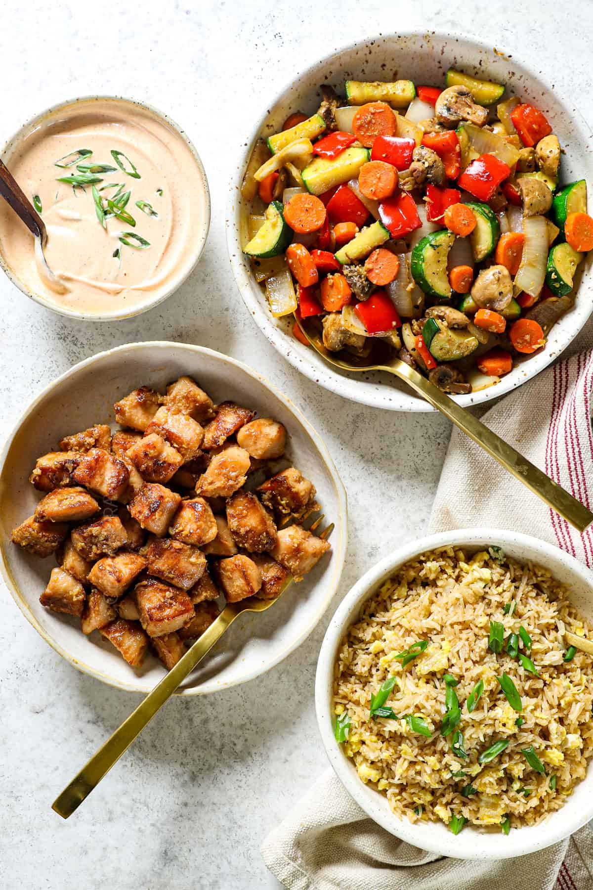 showing ingredients for hibachi chicken: stir fried chicken, stir fried chicken vegetables and fried rice in bowls
