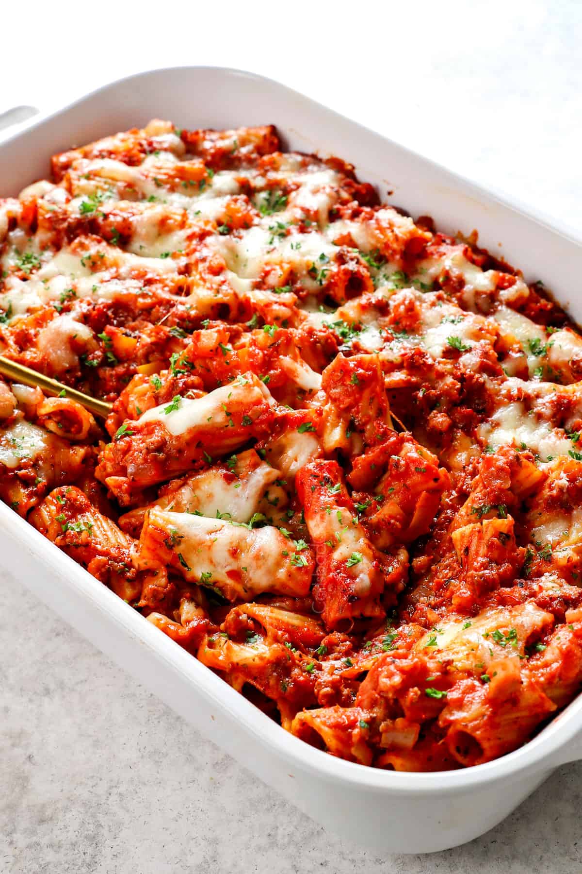 scooping up baked rigatoni recipe showing how cheesy it is