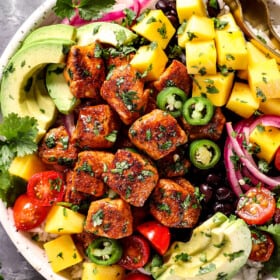 top view of chicken bites being served in a bowl with rice and avocados