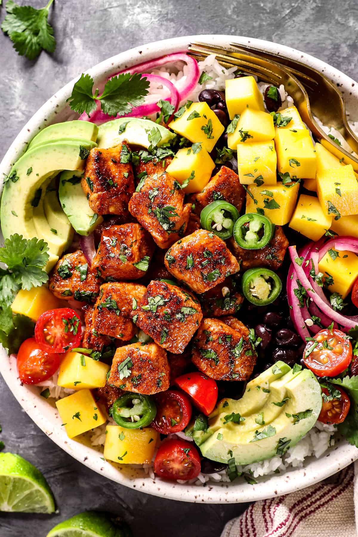 top view of chicken bites being served in a bowl with rice and avocados