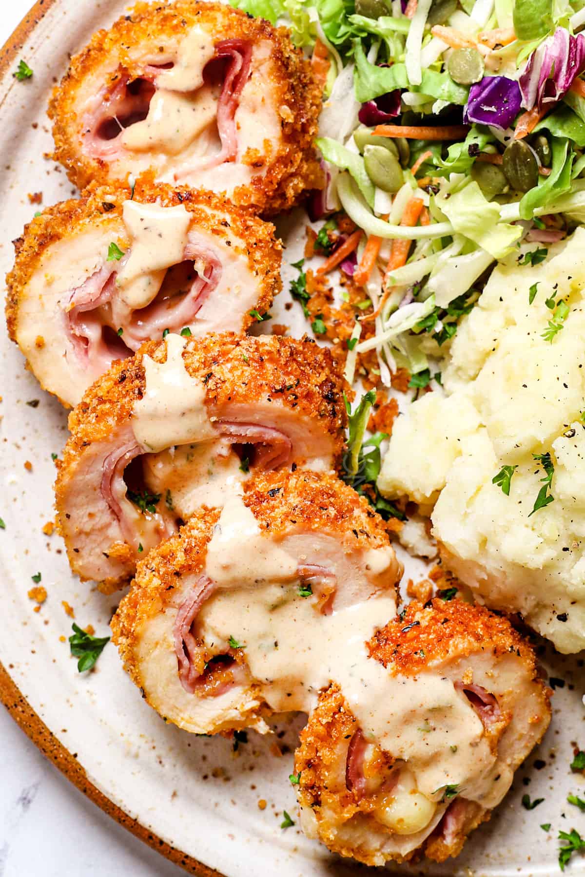 top view of serving chicken cordon bleu recipe by slicing and spooning over chicken cordon bleu sauce