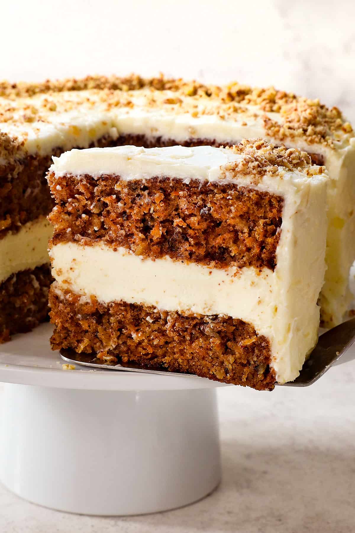 serving a slice of carrot cake cheesecake recipe with cream cheese frosting