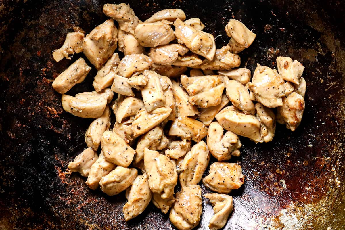 showing how to make pad woon sen by stir frying the chicken in a work until cooked through