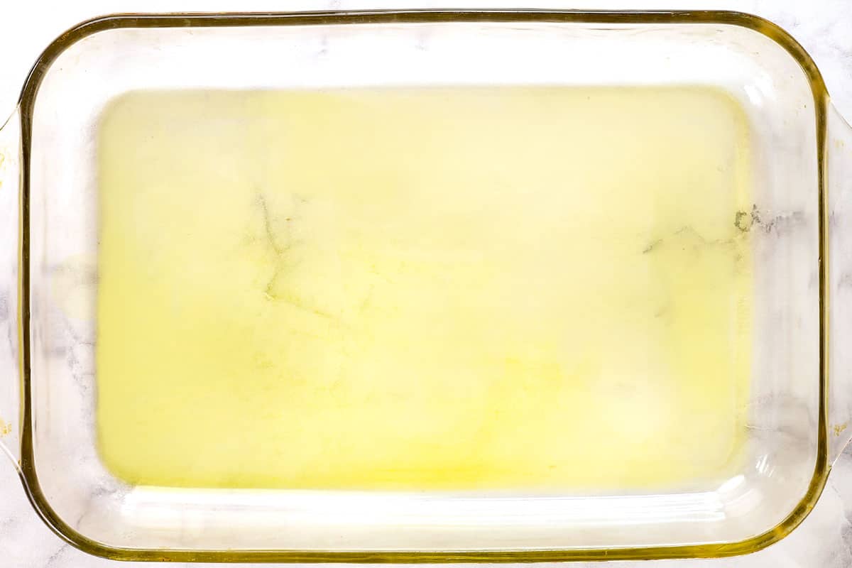 showing how to make crispy Parmesan crusted Potatoes by adding olive oil to the bottom of a 9x13 pan