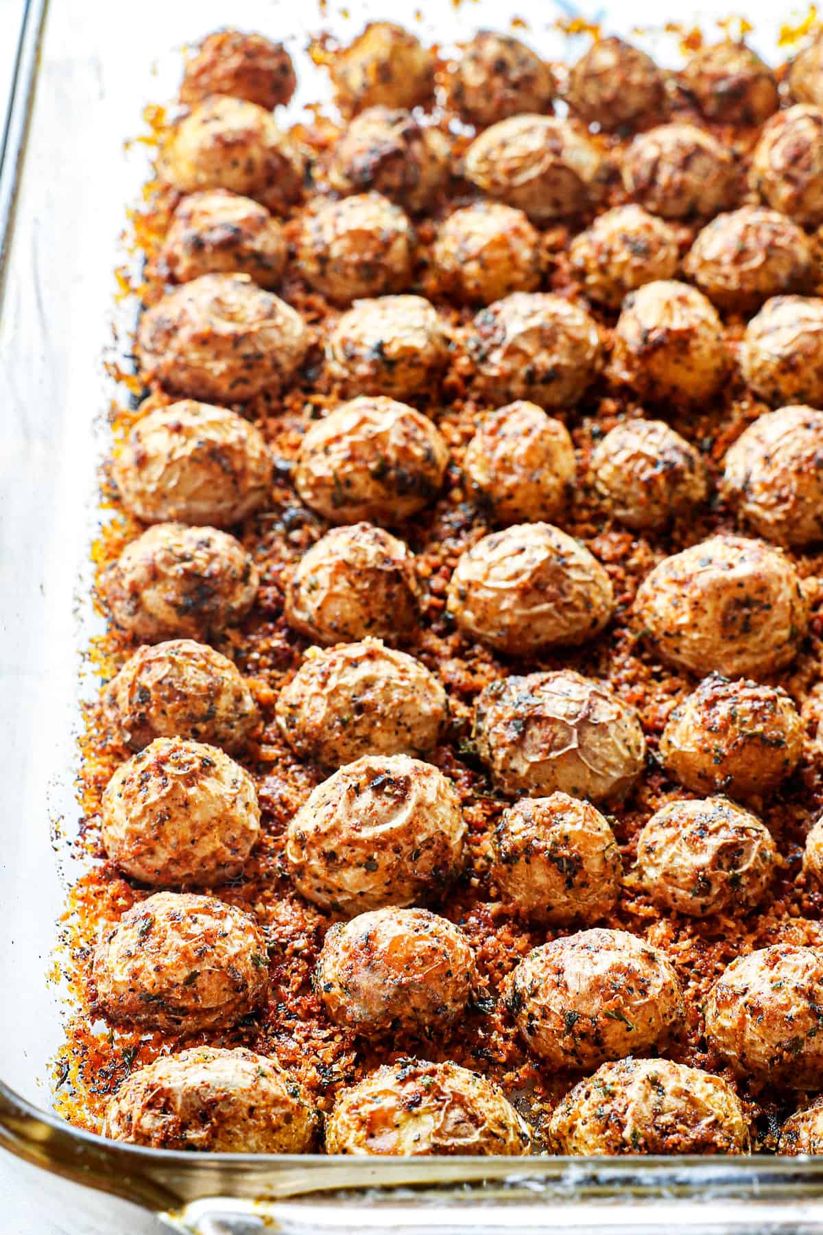 Parmesan crusted potatoes in a baking pan with a crispy Parmesan crust