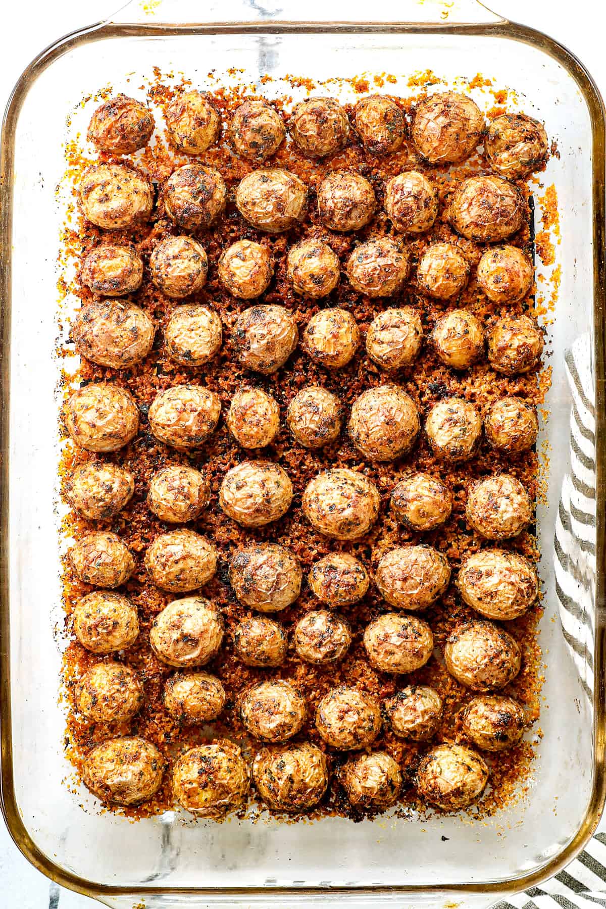showing how to make Parmesan Crusted Potatoes by baking the potatoes in the oven until crispy