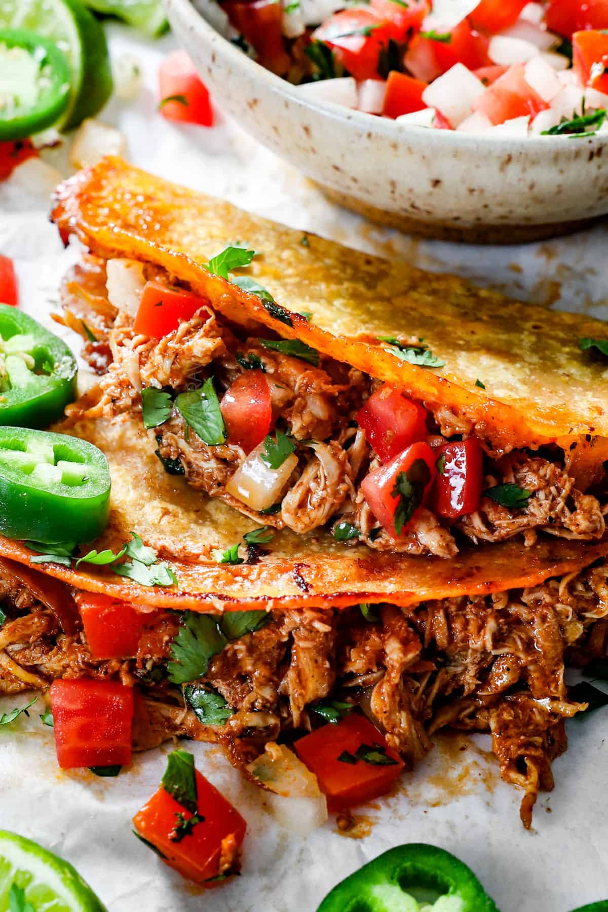 up close of baked chicken tacos showing how crispy the taco shells are and how juicy the chicken is