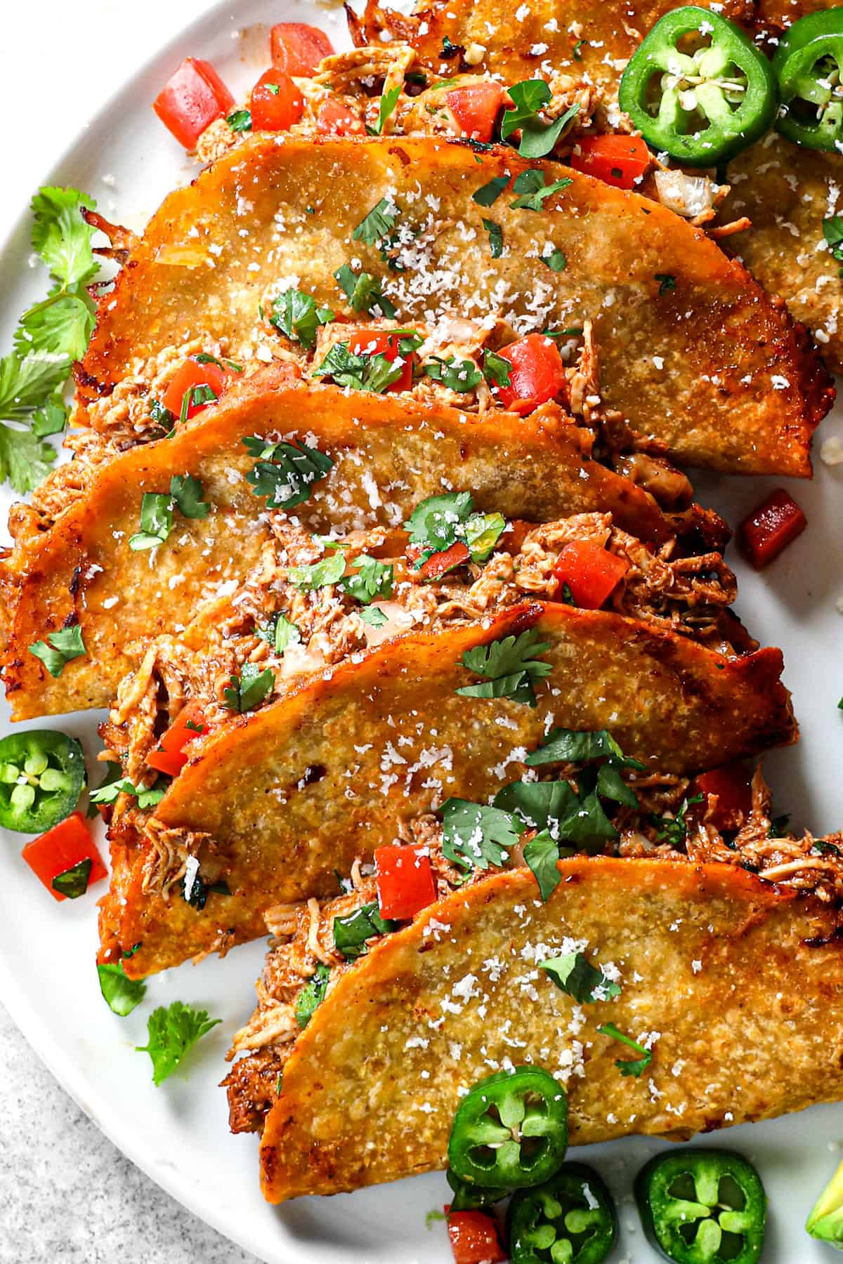 showing how to serve baked chicken tacos on a serving platter with pico de gallo and sour cream