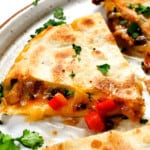 up close of easy chicken quesadilla recipe showing the cheesy chicken filling oozing out the sides