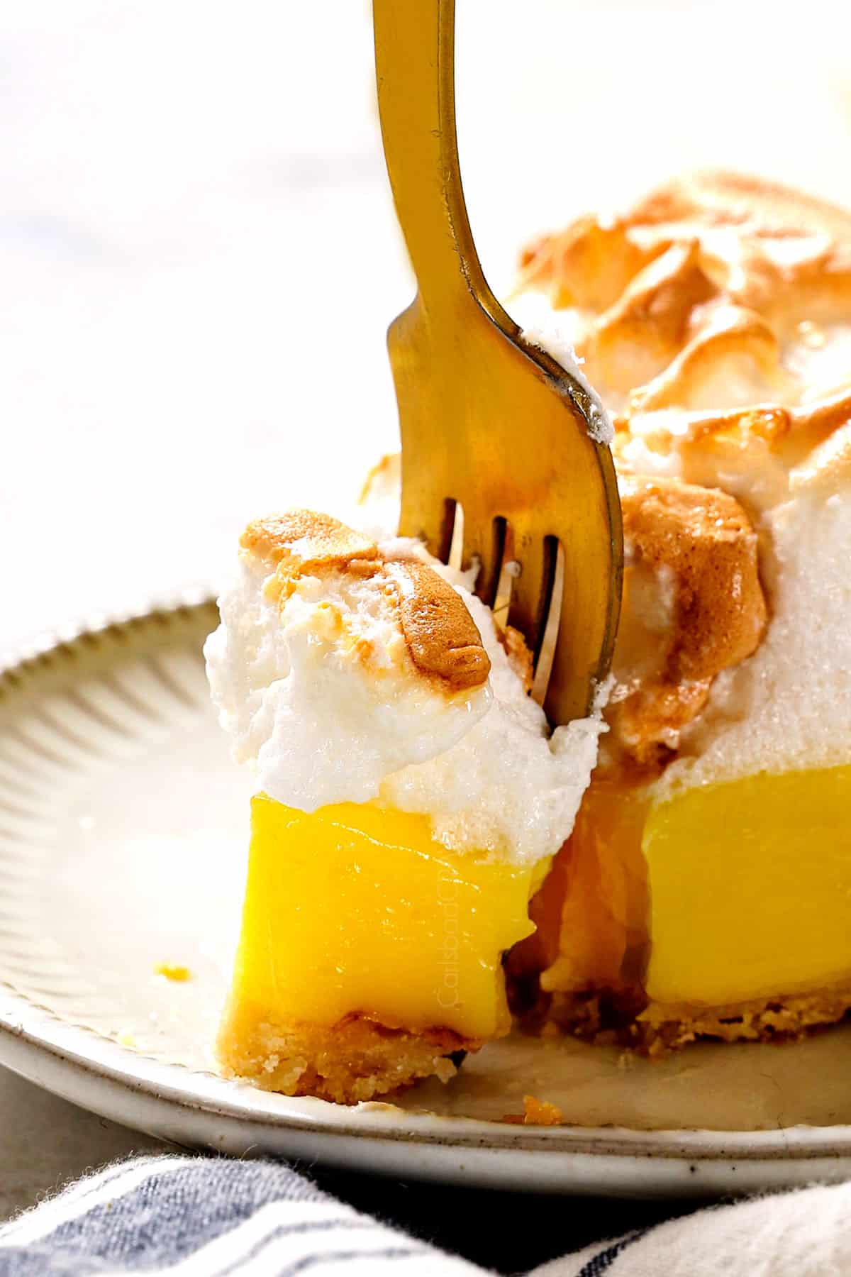 up close of a fork taking a bite of best Lemon Meringue Pie recipe showing how creamy the filling is