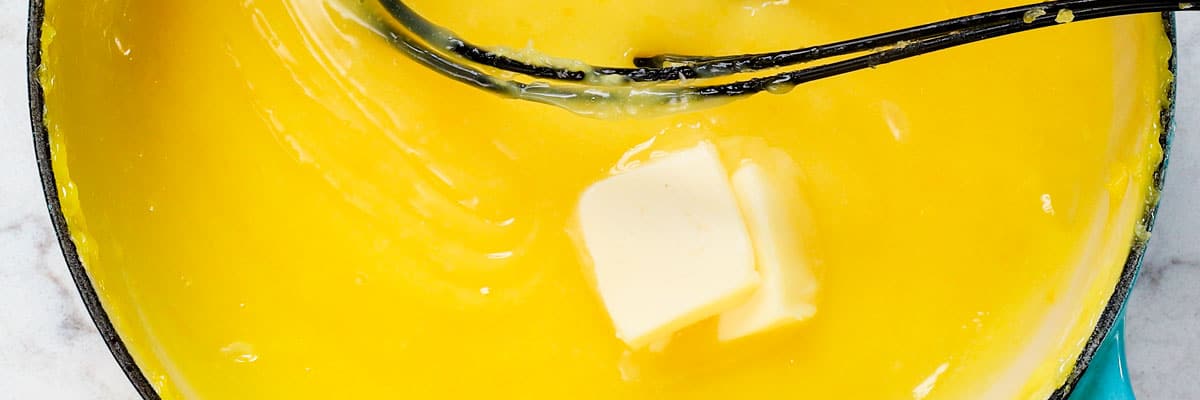 showing how to make best Lemon Meringue Pie Recipe by stirring butter into the lemon filing