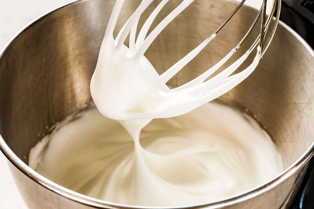 showing how to make meringue for Lemon Meringue Pie by whipping egg whites, sugar and cream of tartar to stiff peaks