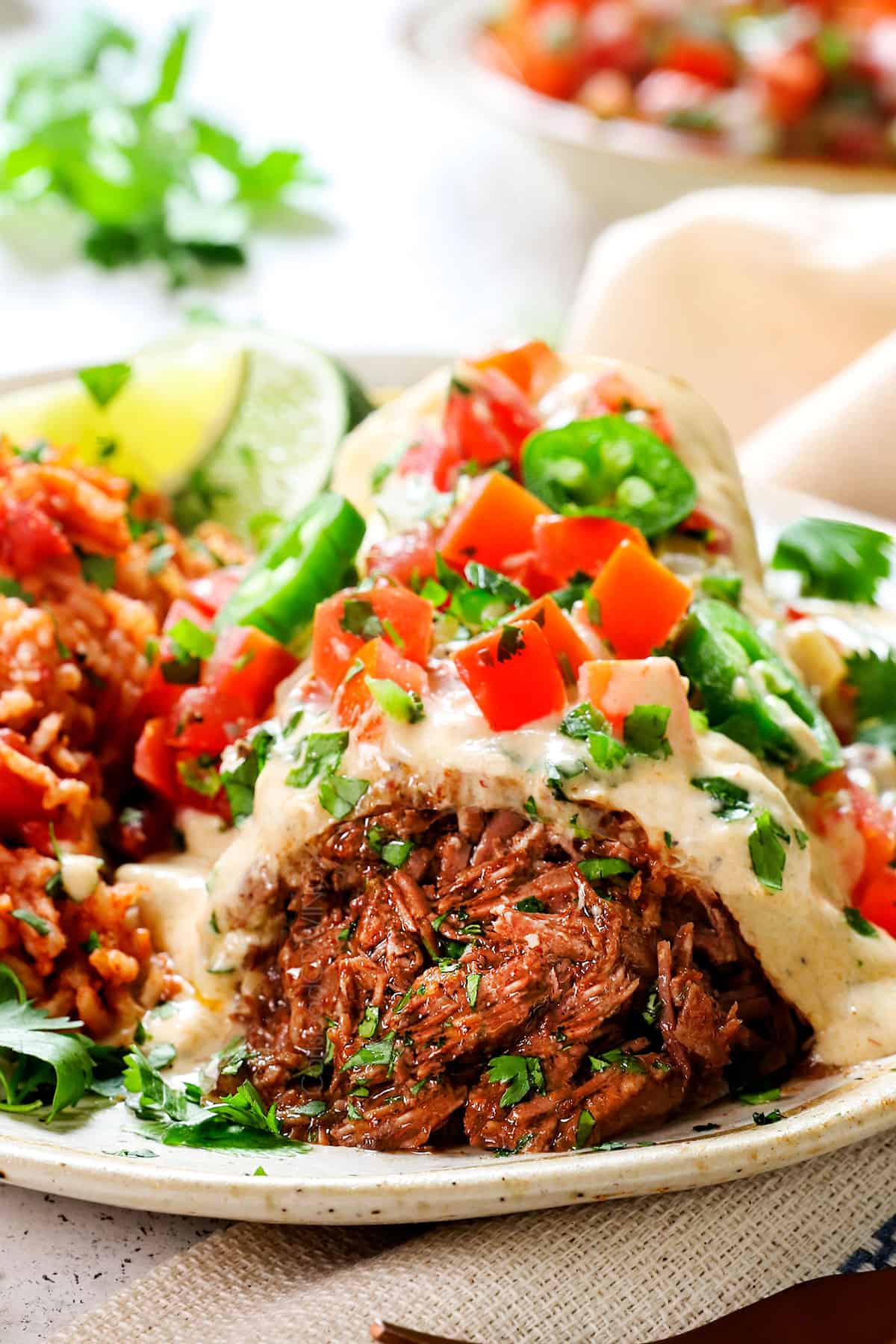 chimichanga with beef being served on a plate smothered in sauce