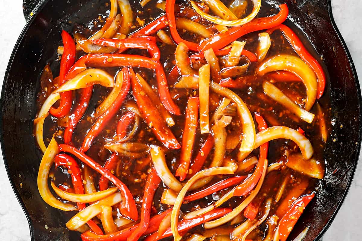 showing how to make spicy Dragon Chicken by adding the sauce to the skillet