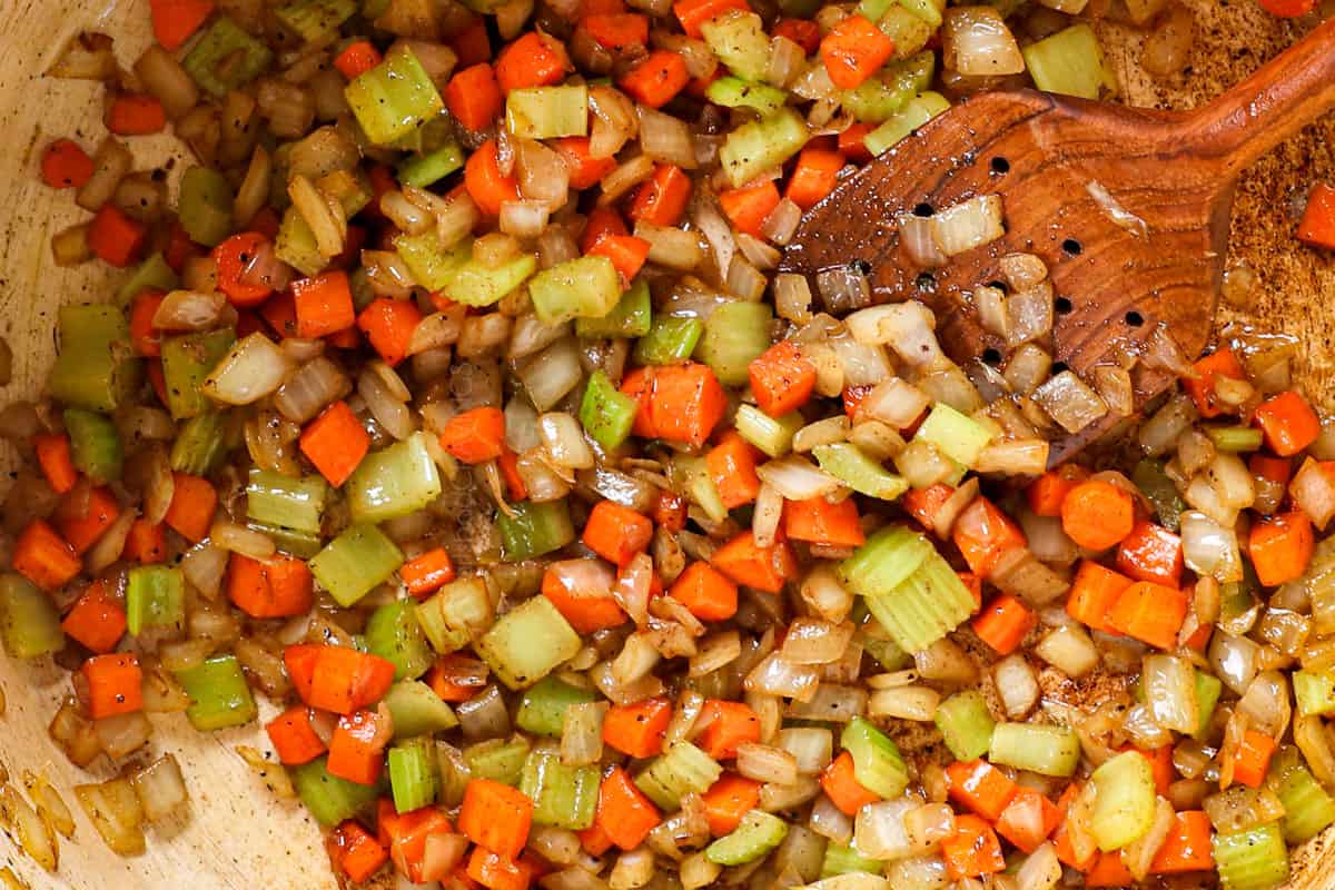showing how to make Beef Noodle Soup by sautéing onions, carrots and celery until onions are softened