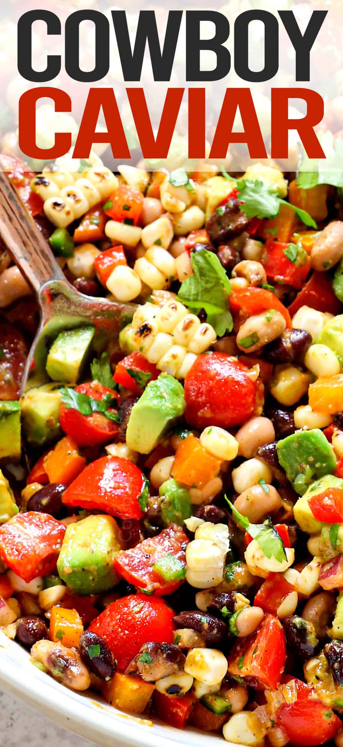 up close serving cowboy caviar recipe (Texas Caviar) with black beans, black eyed peas, bell peppers, corn, red onions, and avocados
