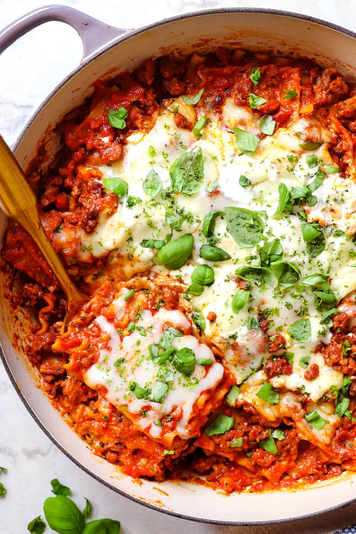 showing how to make skillet lasagna recipe by melting the mozzarella, ricotta and Parmesan in the oven