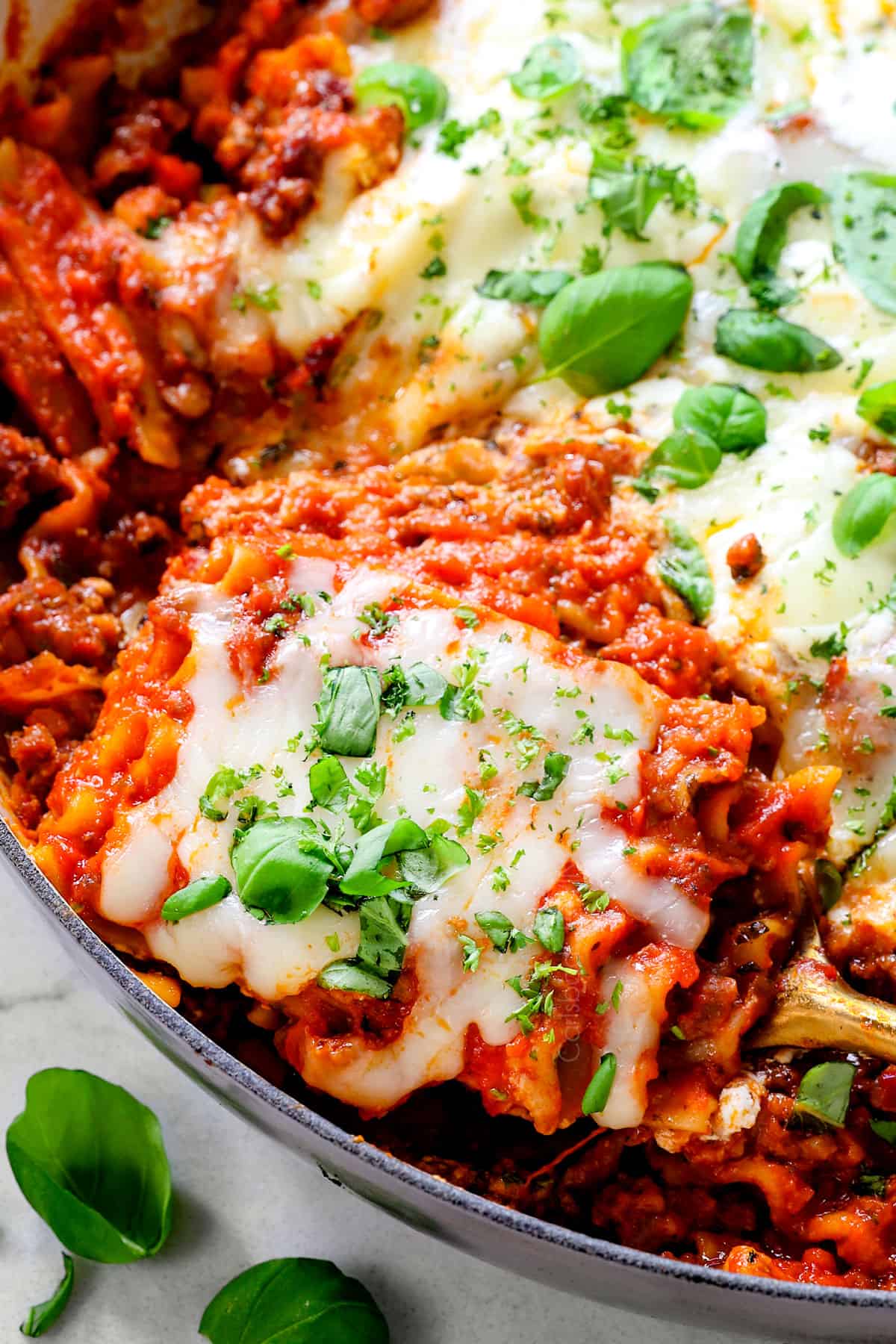 up close of serving easy lasagna in a skillet showing the tender noodles, cheese and marinara sauce