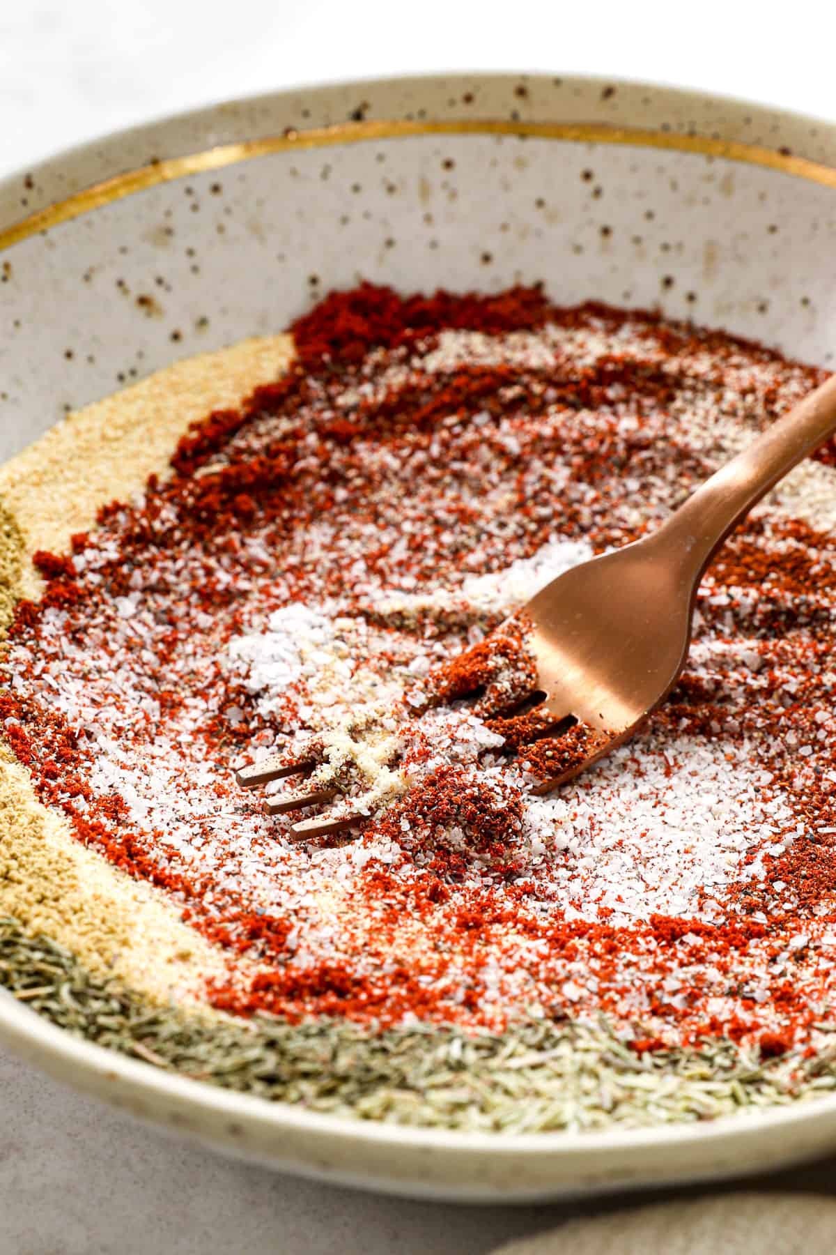 showing how to make steak seasoning recipe by whisking the spices together until evenly combined