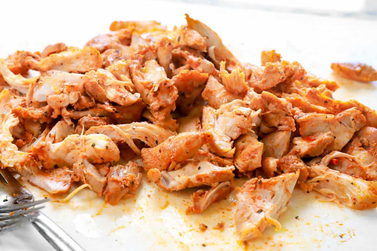 showing how to make Thai curry chicken in the crockpot by shredding the chicken once tender