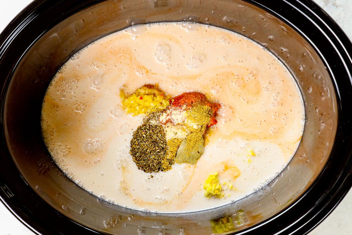 showing how to make crockpot curry chicken by adding red curry paste, coconut milk, soy sauce, fish sauce, lime juice, red chili paste, garlic, ginger and basil to a crockpot